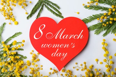 Image of Beautiful mimosa flowers and heart shaped greeting card with text 8 March Women's Day on grey background, flat lay 