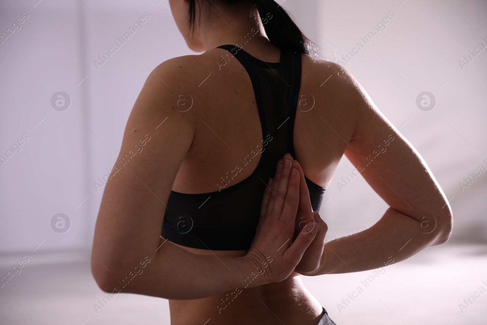 Photo of Young woman practicing seiza asana in yoga studio, closeup. Vajrasana pose
