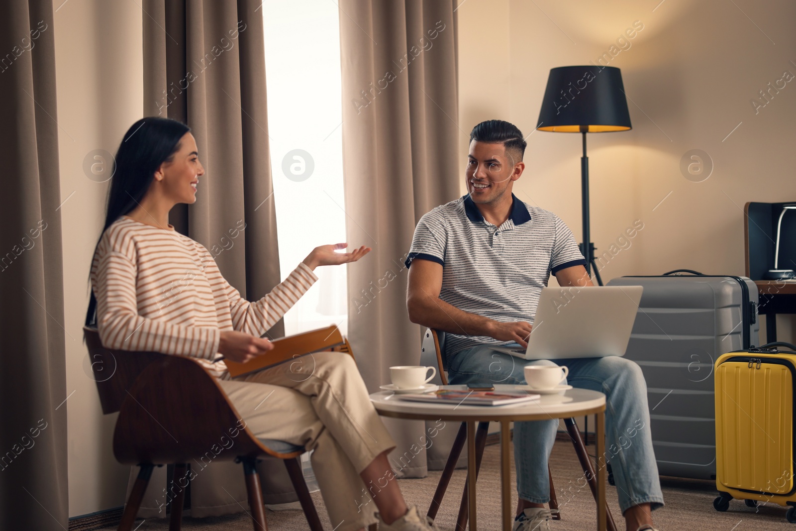 Photo of Happy couple spending time together in hotel room