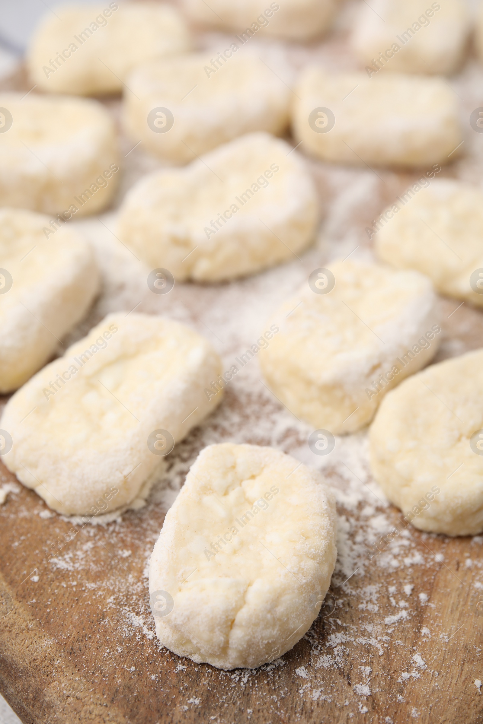 Photo of Making lazy dumplings. Cut dough and flour on wooden board, closeup