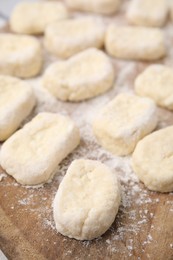 Photo of Making lazy dumplings. Cut dough and flour on wooden board, closeup