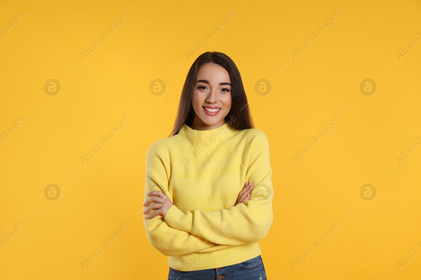 Photo of Beautiful young woman wearing warm sweater on yellow background