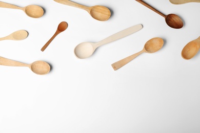 Set of different wooden spoons on white background, top view