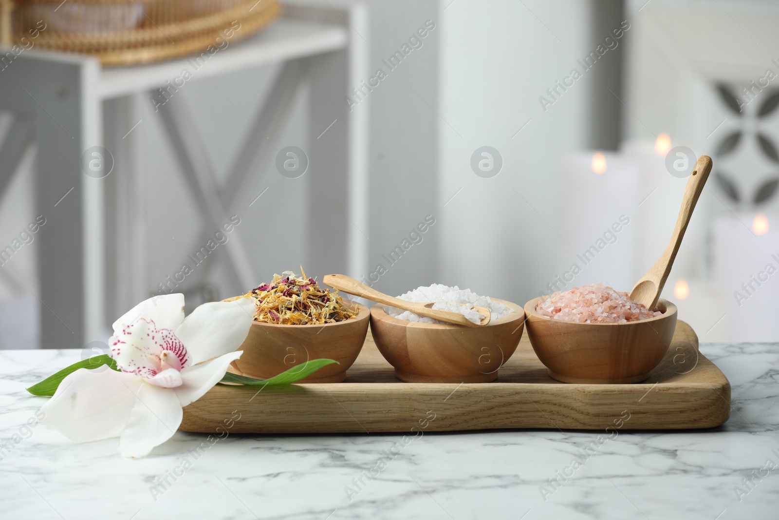 Photo of Spa composition. Sea salt, dry flowers and orchid on white marble table indoors