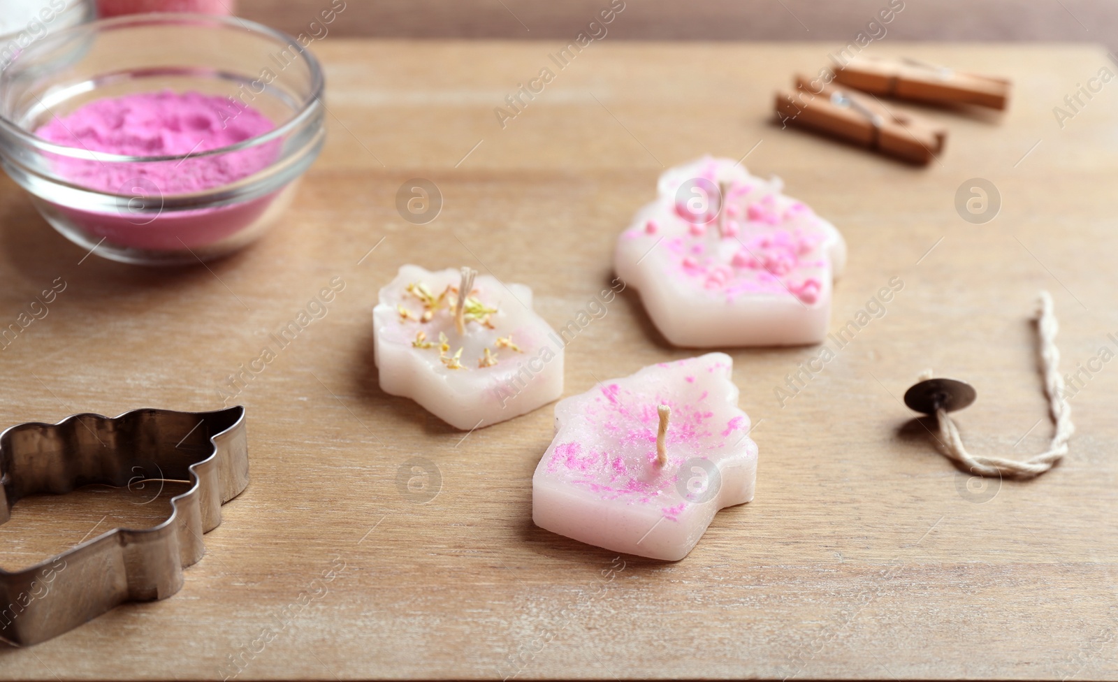 Photo of Handmade candles with cutter on wooden background