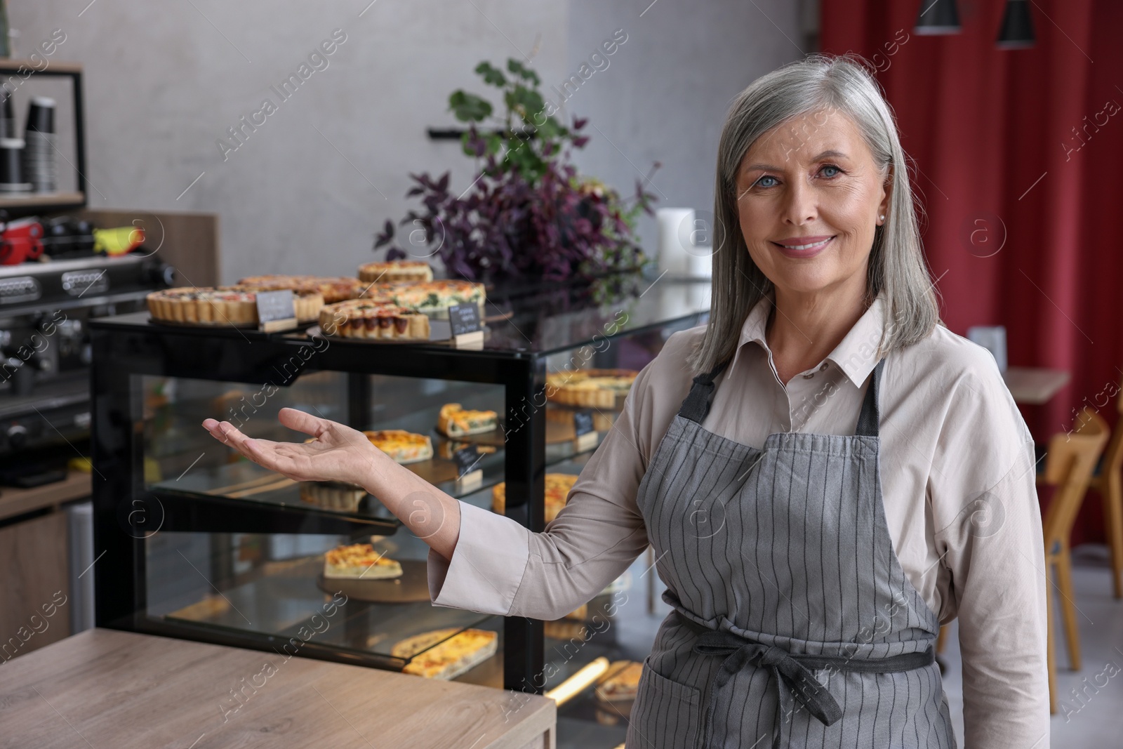 Photo of Happy business owner inviting to come into her cafe