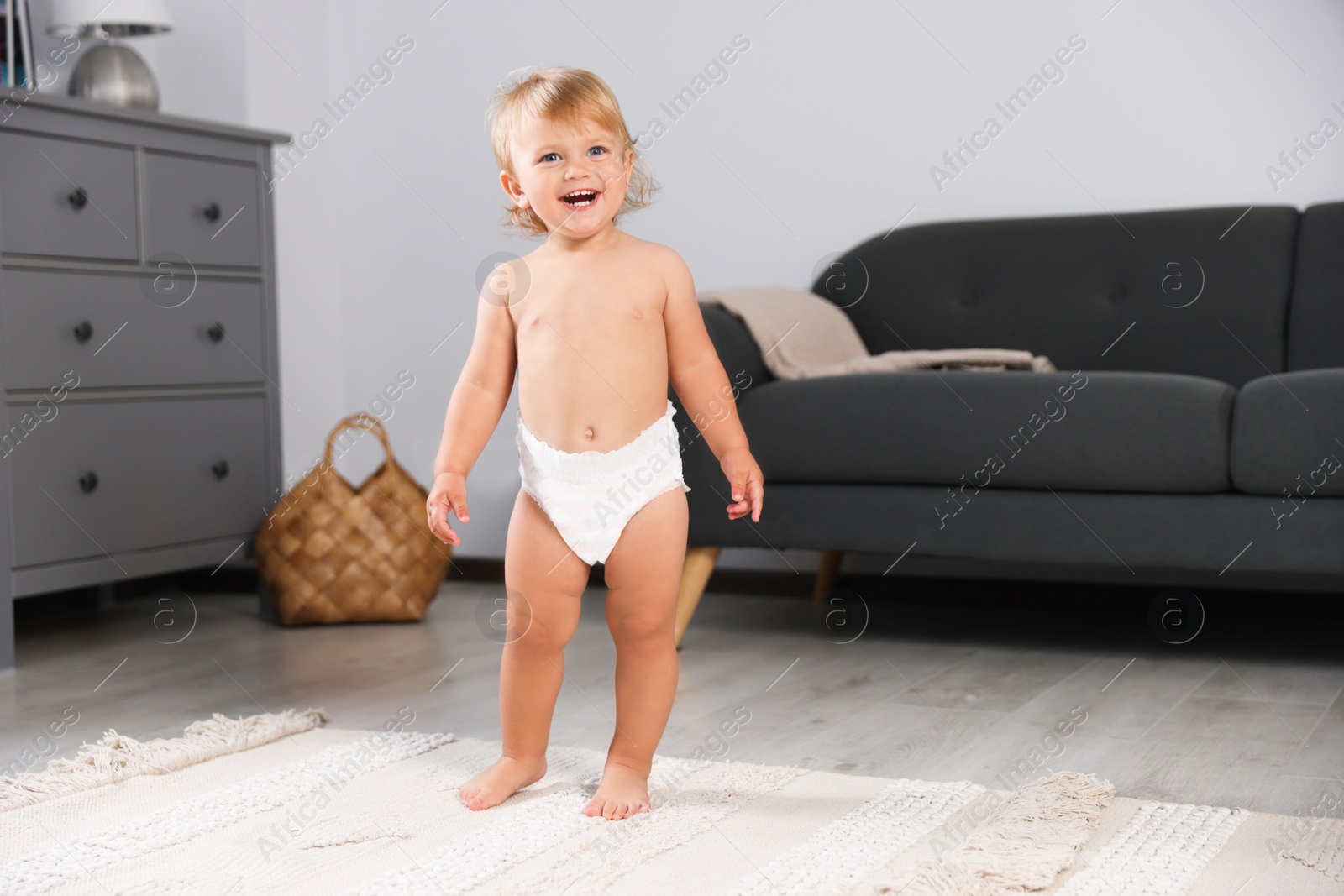 Photo of Cute baby learning to walk in living room