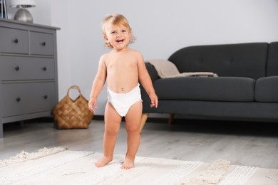 Cute baby learning to walk in living room