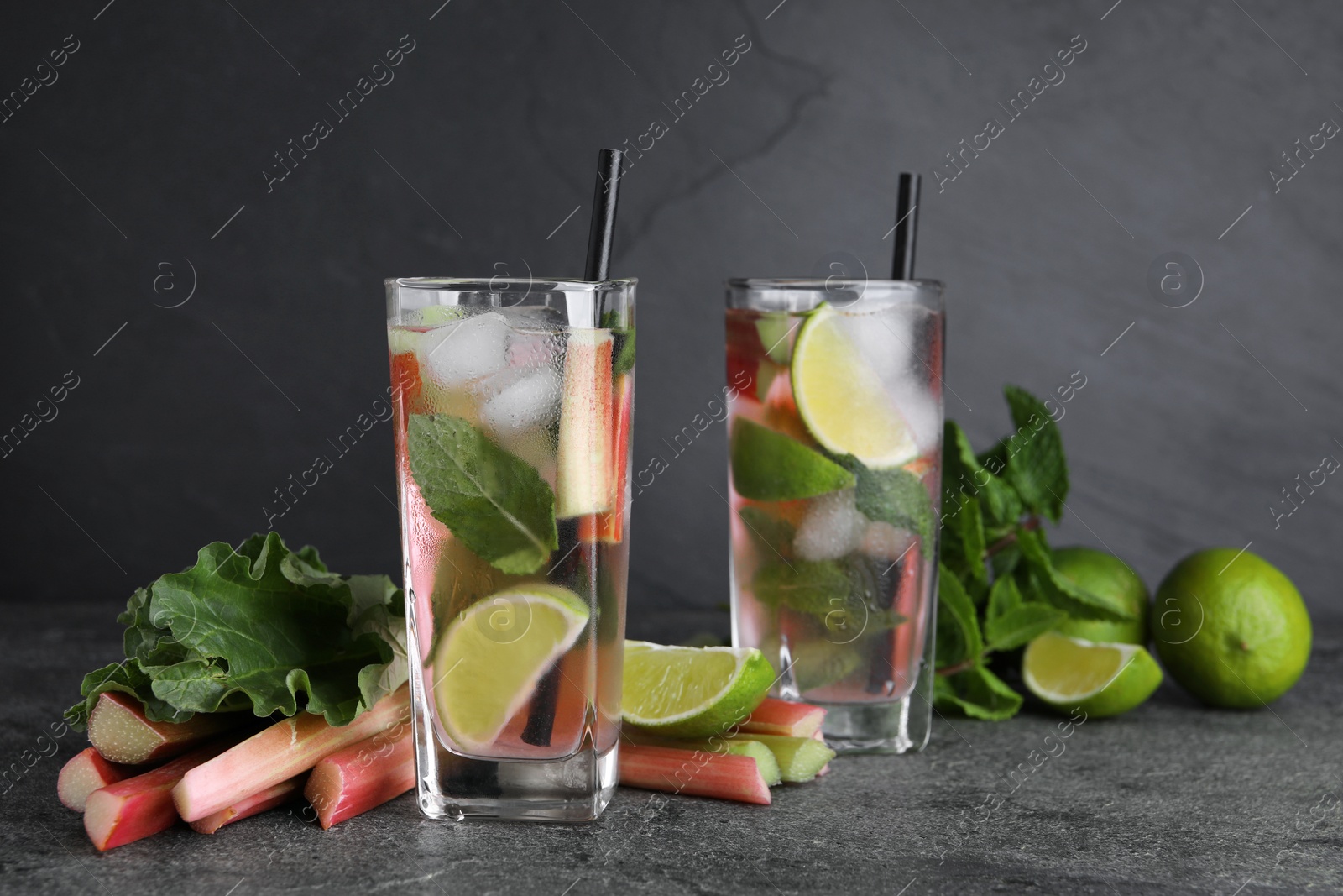 Photo of Tasty rhubarb cocktail with lime on black table