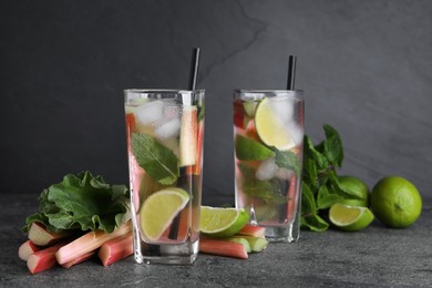 Tasty rhubarb cocktail with lime on black table