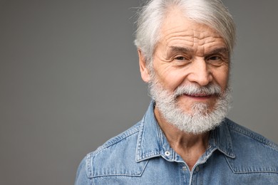 Senior man with mustache on grey background, space for text