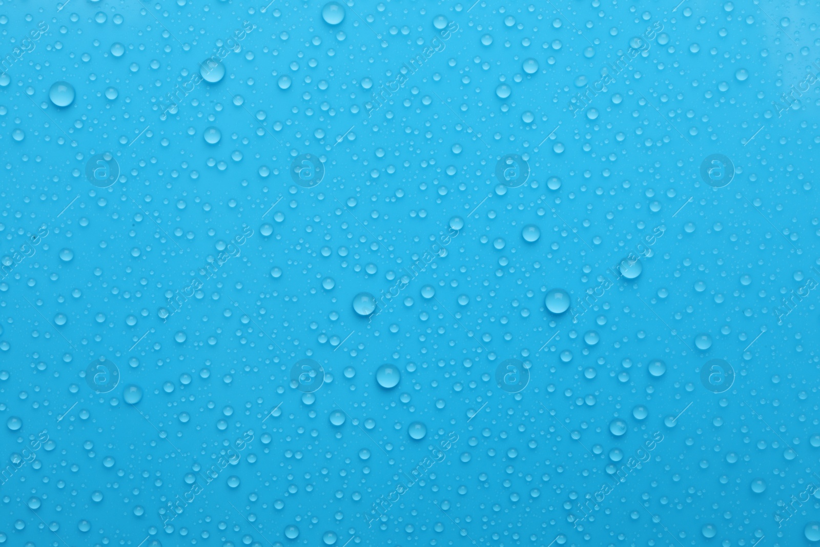 Photo of Water drops on light blue background, top view