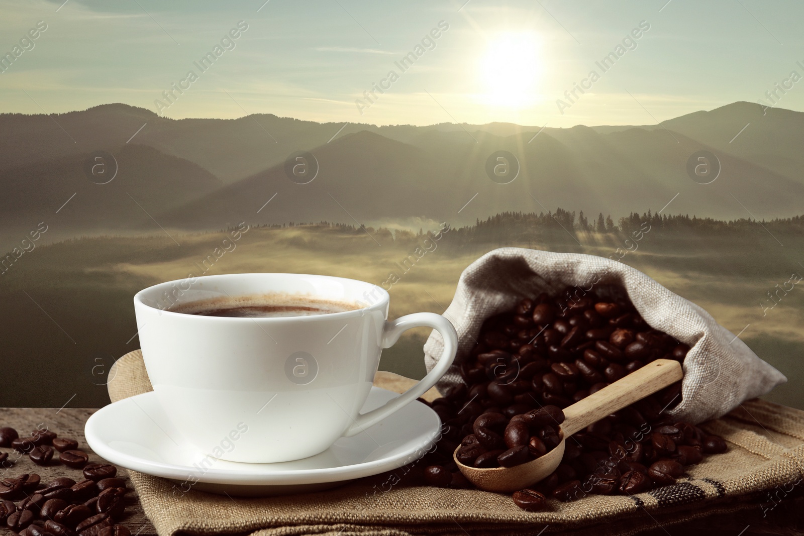 Image of Cup of aromatic hot coffee on wooden table and beautiful view of mountain landscape