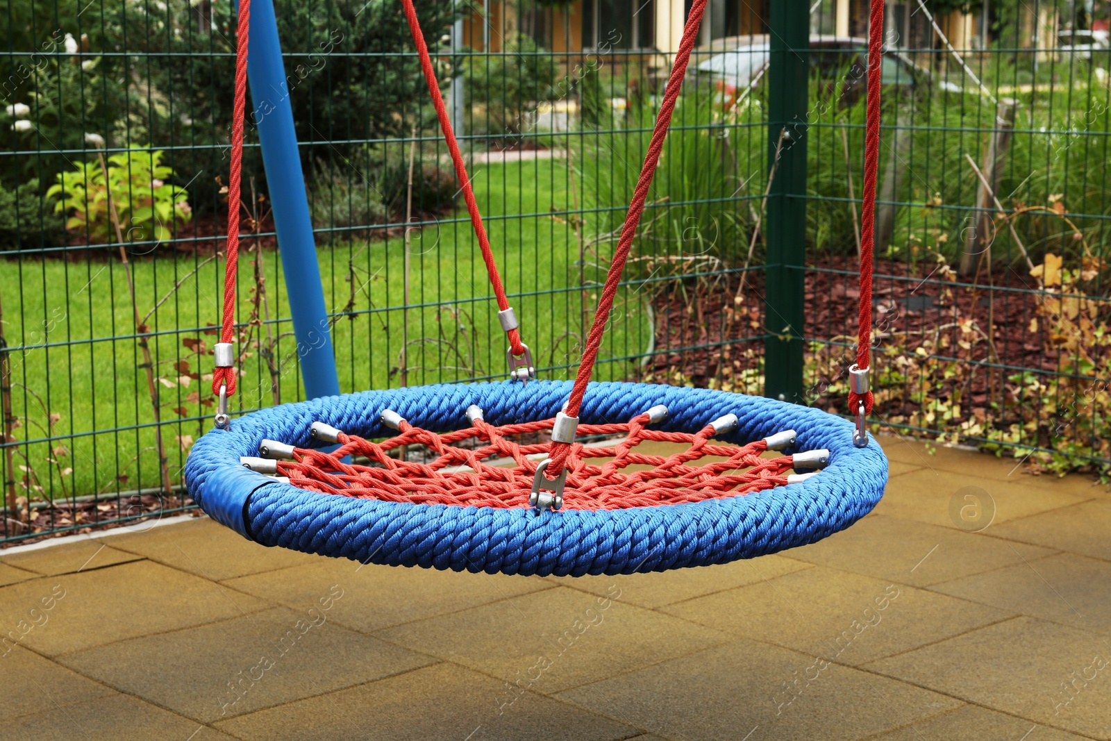 Photo of Light blue nest swing on outdoor playground in residential area