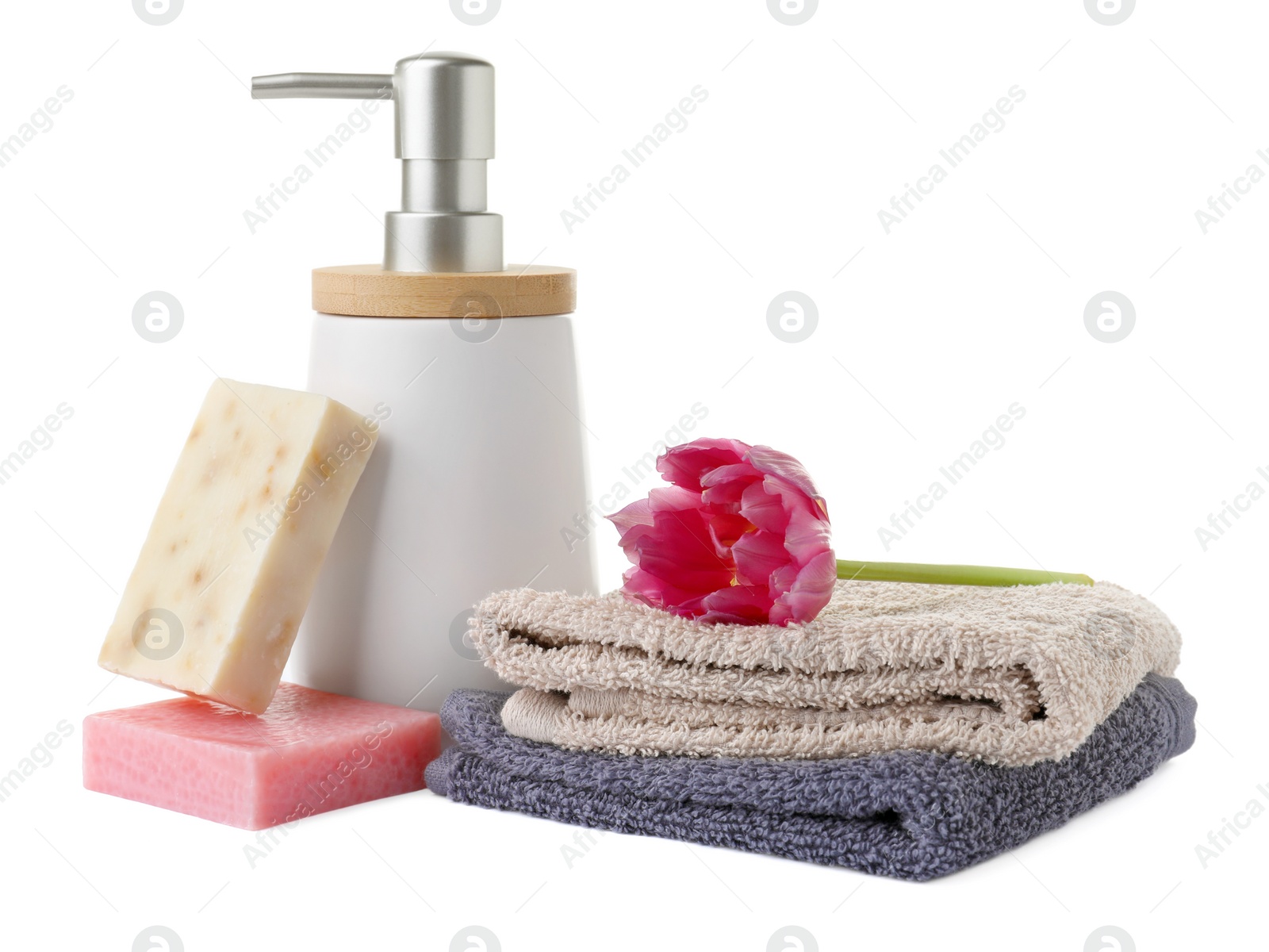 Photo of Soap bars, dispenser and terry towels on white background