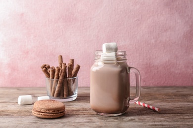 Photo of Tasty hot cocoa drink and delicious treats on table
