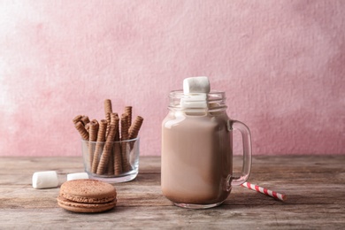 Tasty hot cocoa drink and delicious treats on table