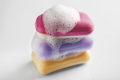 Stack of soap bars with foam on white background