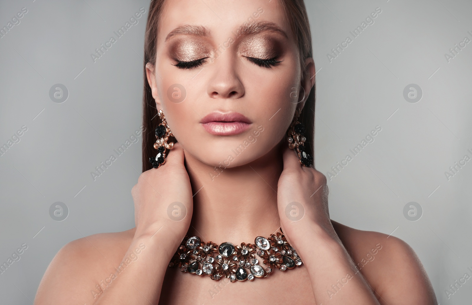 Photo of Beautiful woman with stylish jewelry on grey background