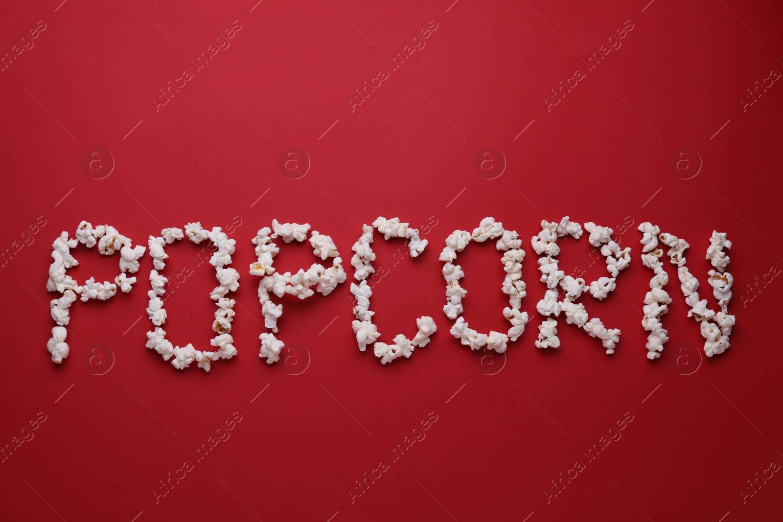 Photo of Word Popcorn made of tasty ingredients on red background, flat lay