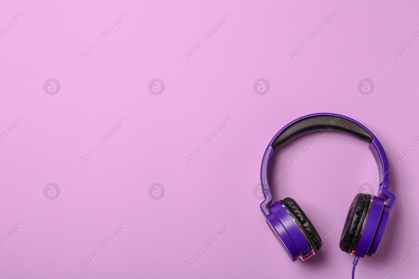 Photo of Stylish modern headphones on color background, top view. Space for text