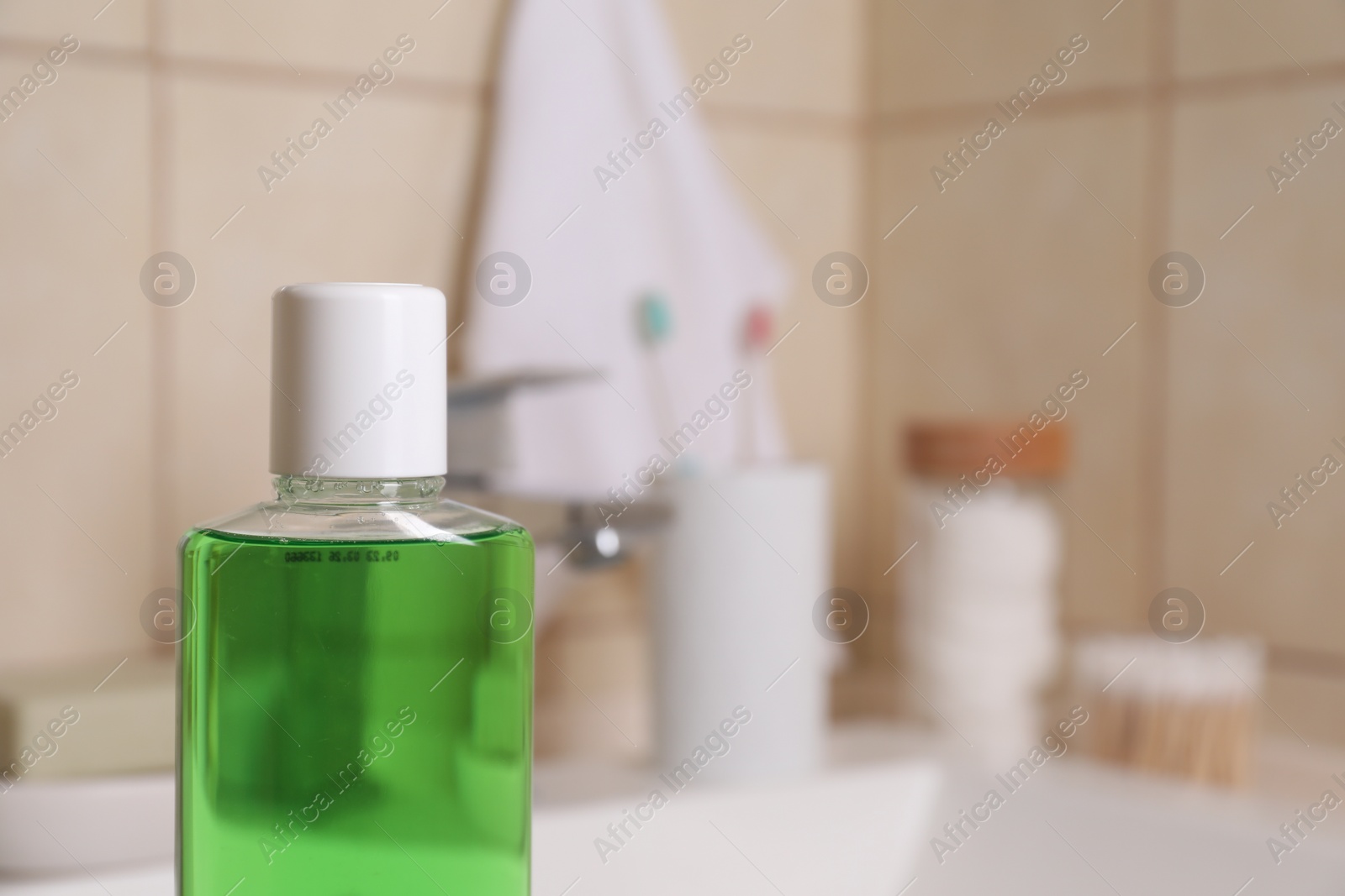 Photo of Bottle with fresh mouthwash in bathroom, closeup. Space for text