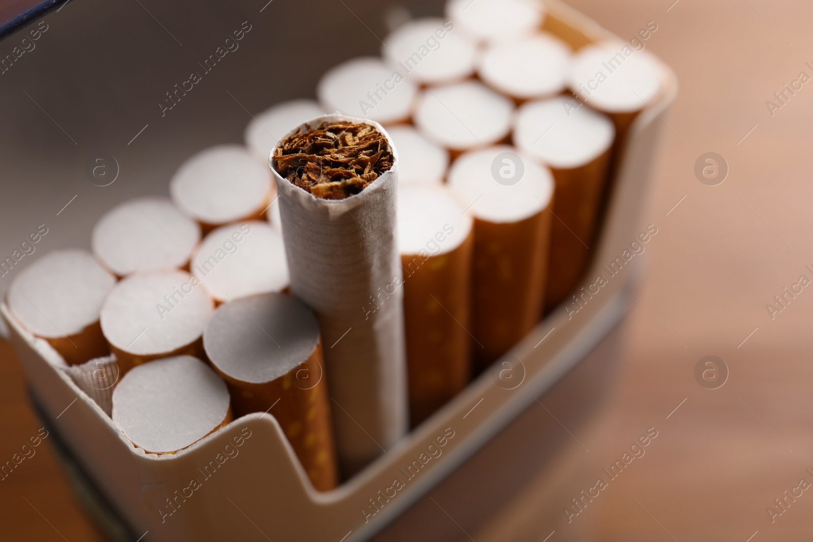 Photo of Pack of cigarettes on blurred background, closeup