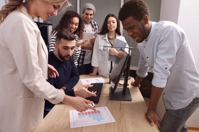 Photo of Team of employees working together in office. Startup project