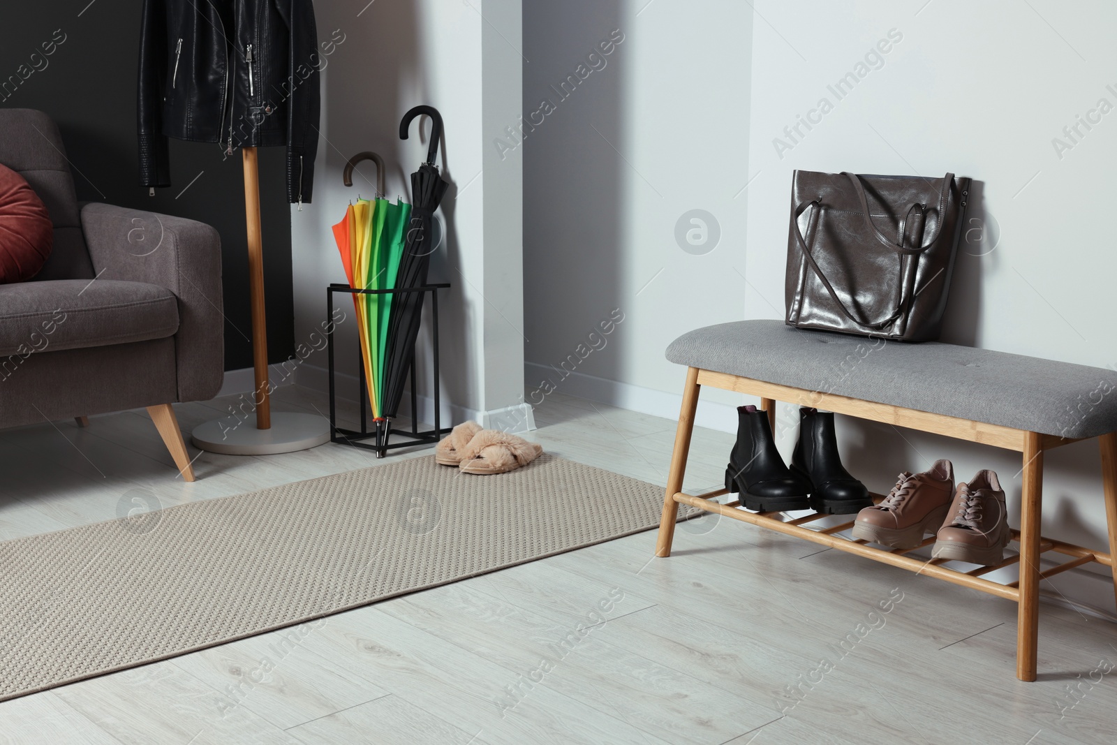 Photo of Shoe storage bench near white wall in hallway. Interior design