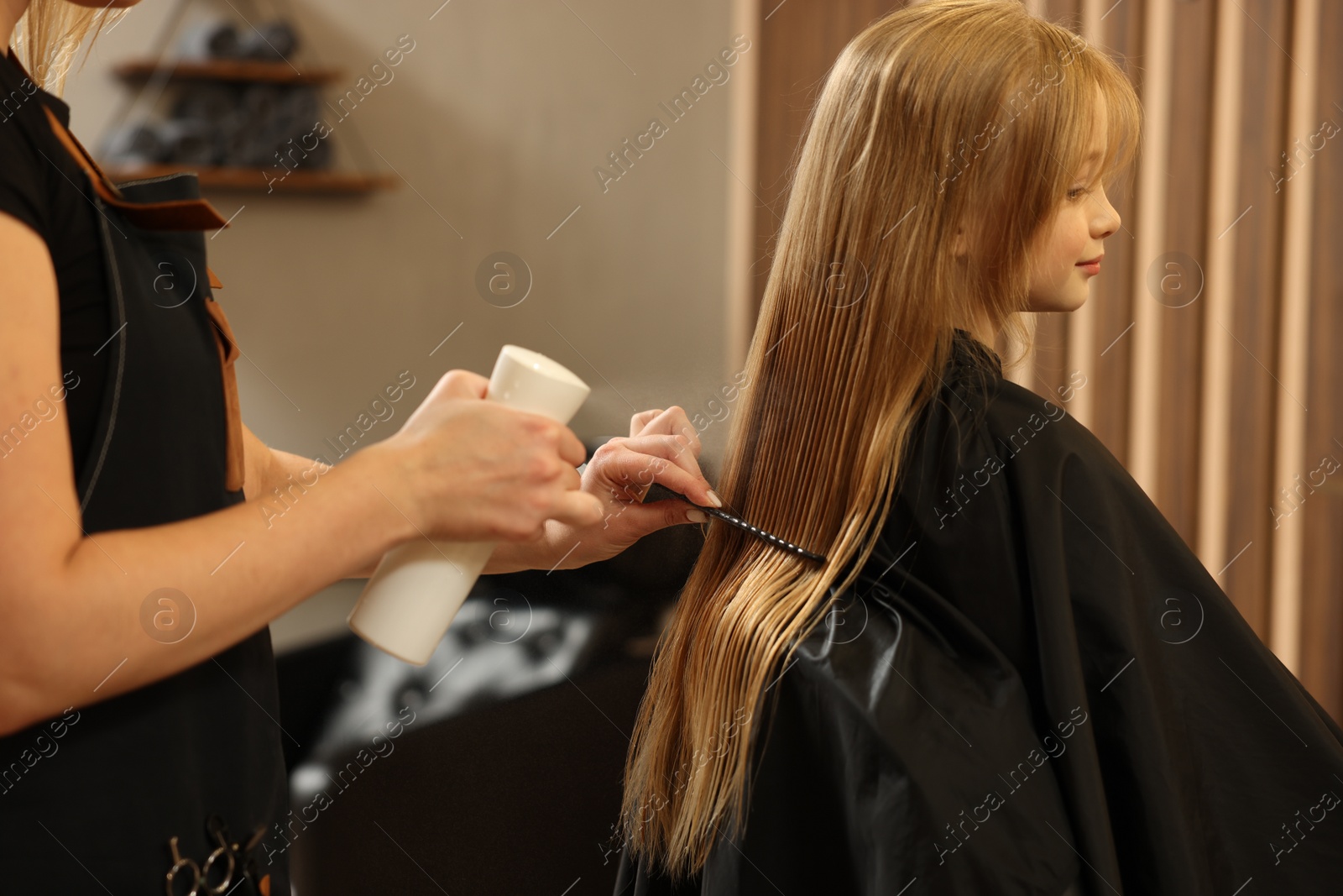 Photo of Professional hairdresser working with girl in beauty salon