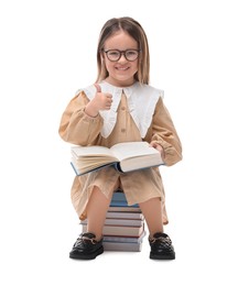 Photo of Cute little girl with books showing thumbs up against white background