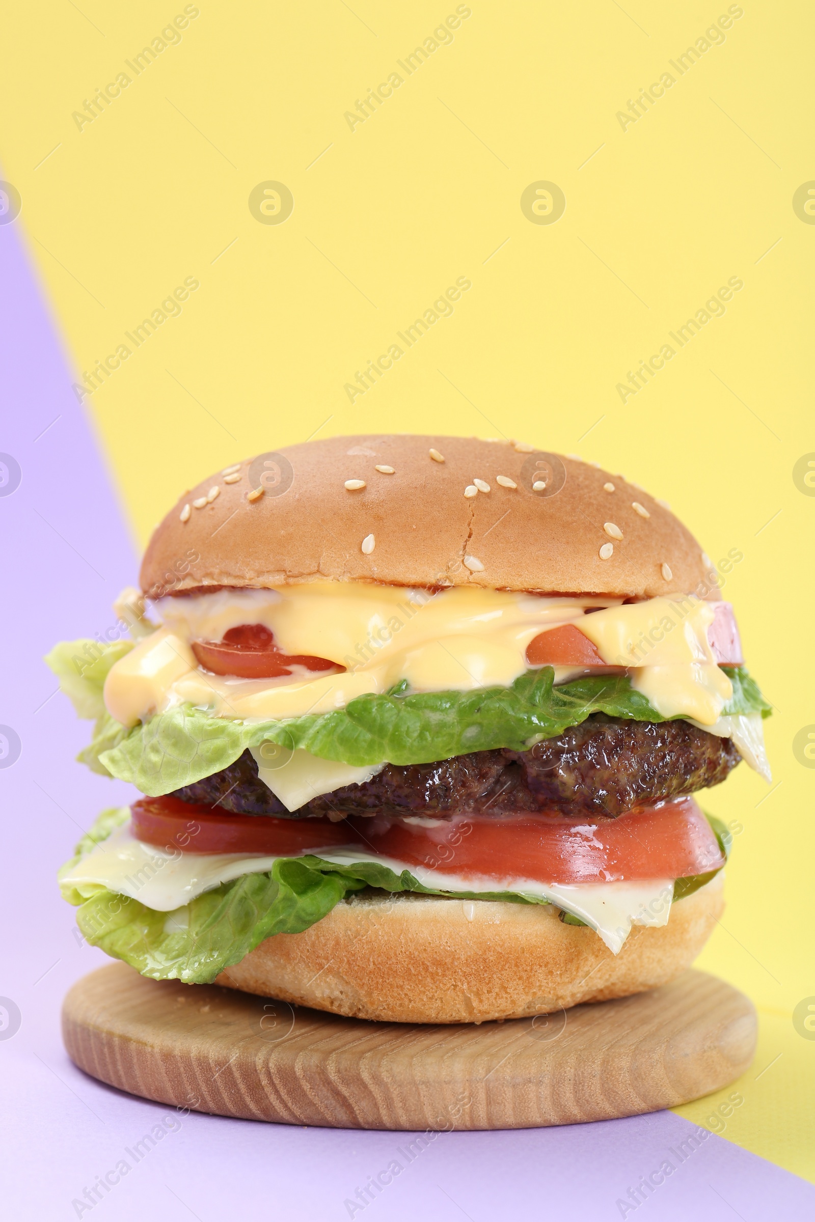 Photo of Burger with delicious patty on color background