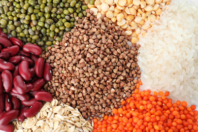 Different types of legumes and cereals as background, top view. Organic grains