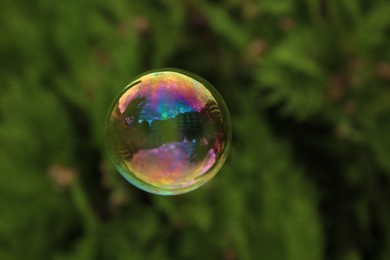 Photo of One beautiful clear soap bubble floating outdoors