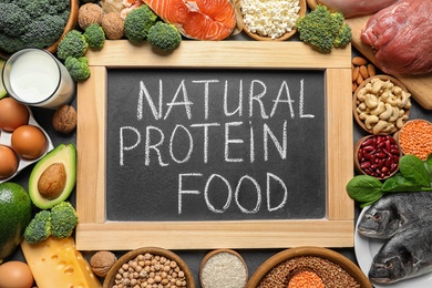 Photo of Chalkboard with written text Natural Protein Food among products, top view
