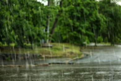 Blurred view of heavy pouring rain in green park