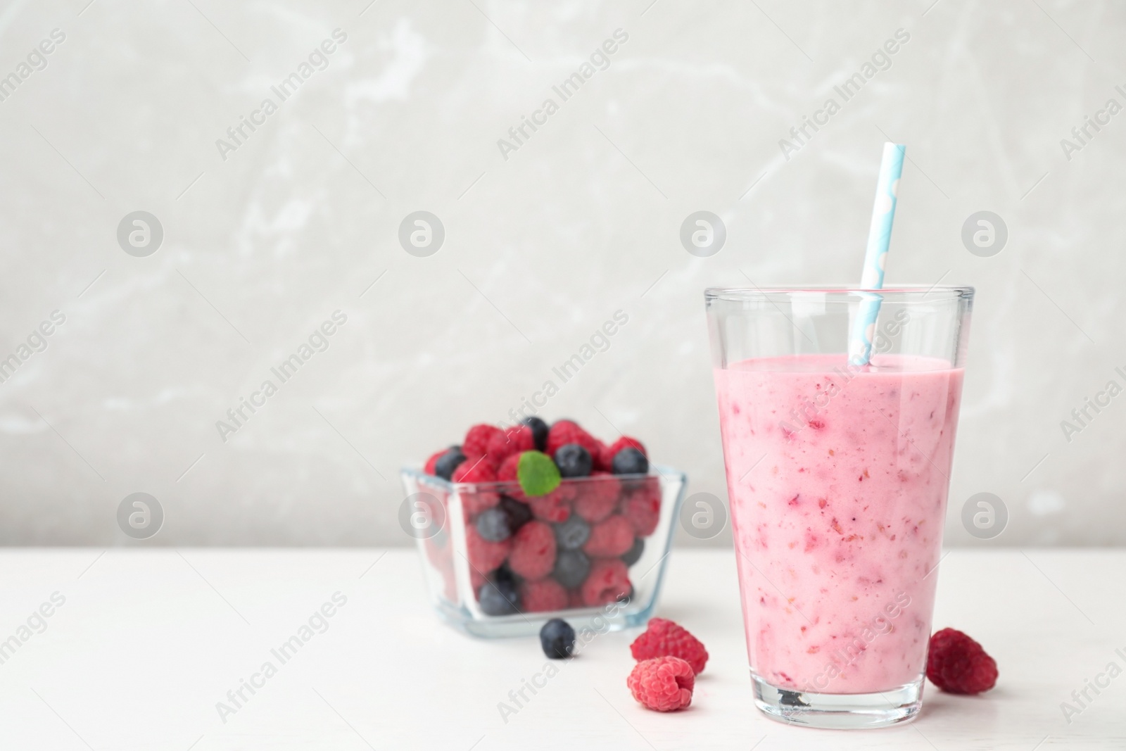 Photo of Delicious smoothie with raspberries in glass on table