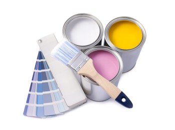 Cans with different paints, brush and color palette on white background, top view