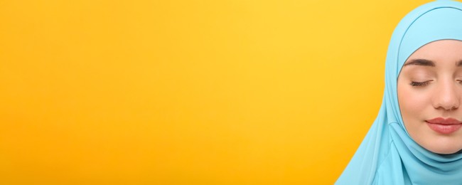 Image of Portrait of Muslim woman in hijab on yellow background, space for text. Banner design
