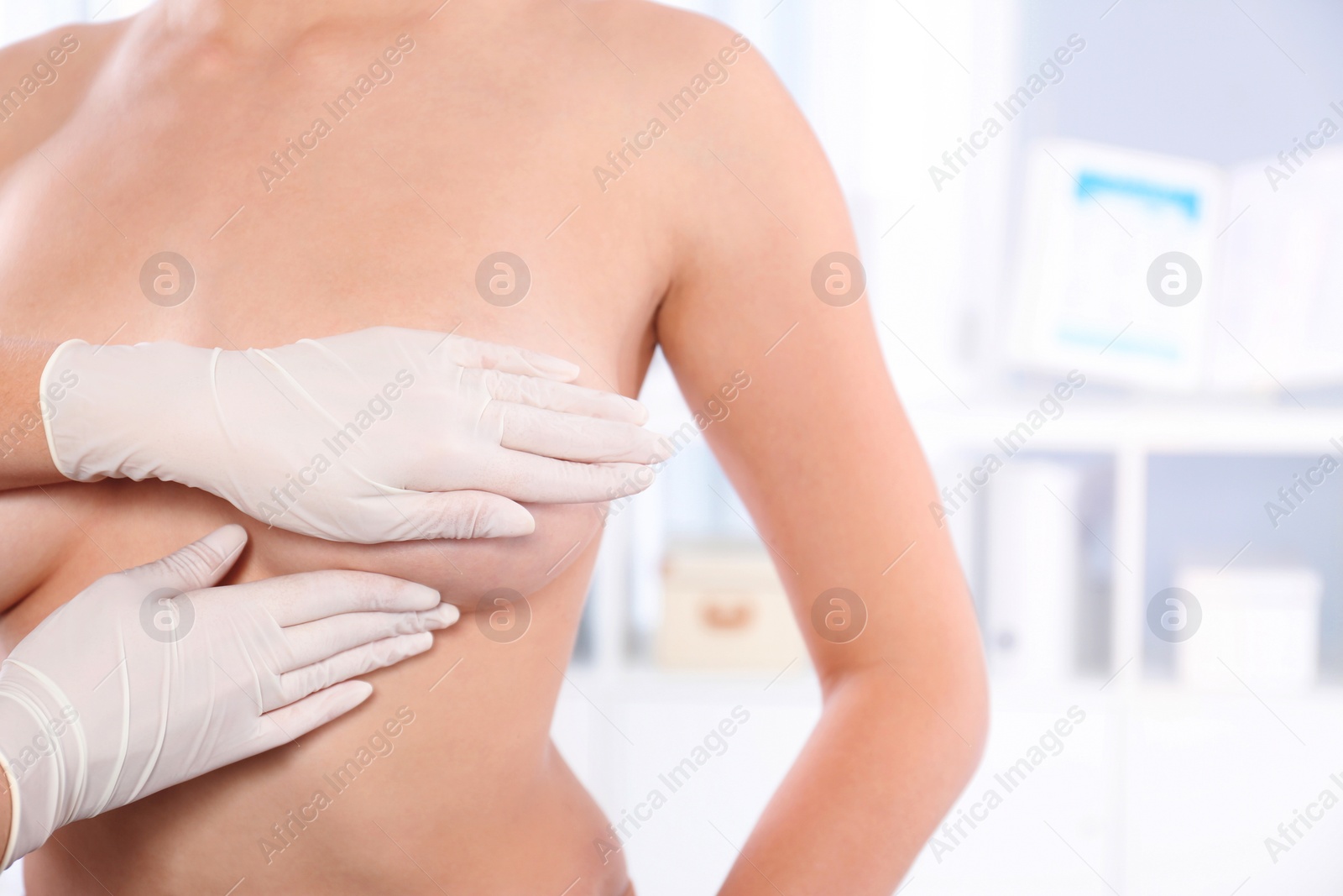 Photo of Doctor checking woman's breast at hospital, closeup