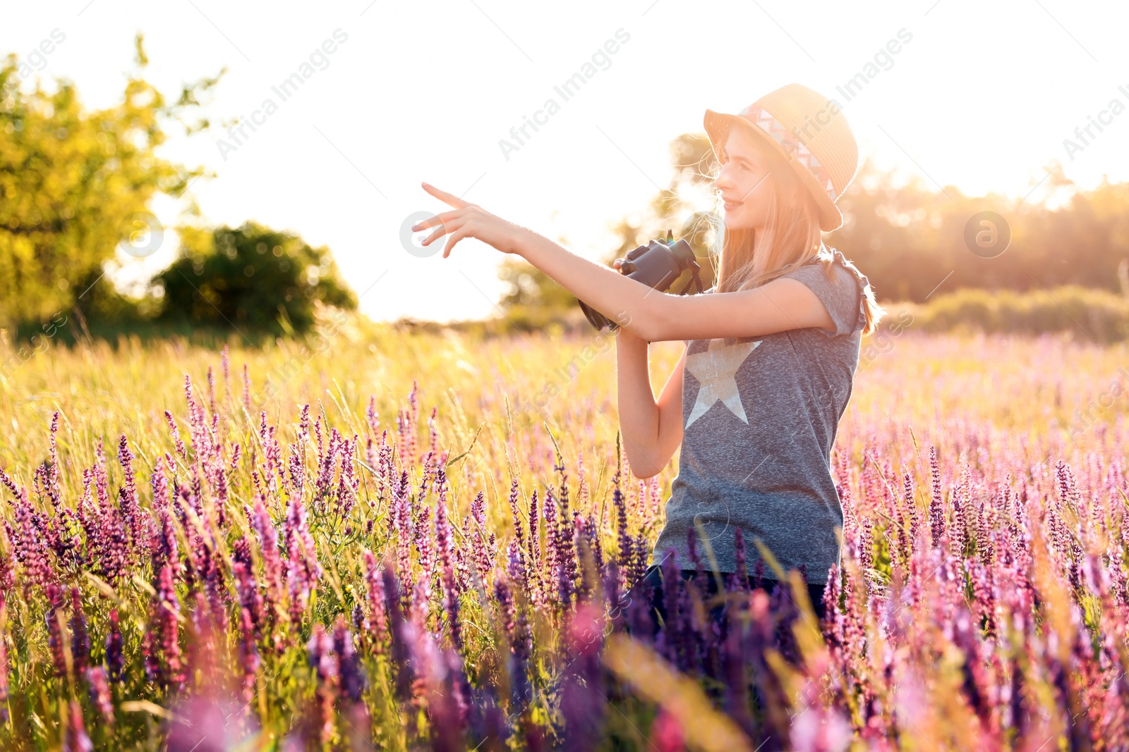 Photo of Teenage girl with binoculars in field. Summer camp