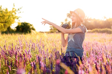 Teenage girl with binoculars in field. Summer camp