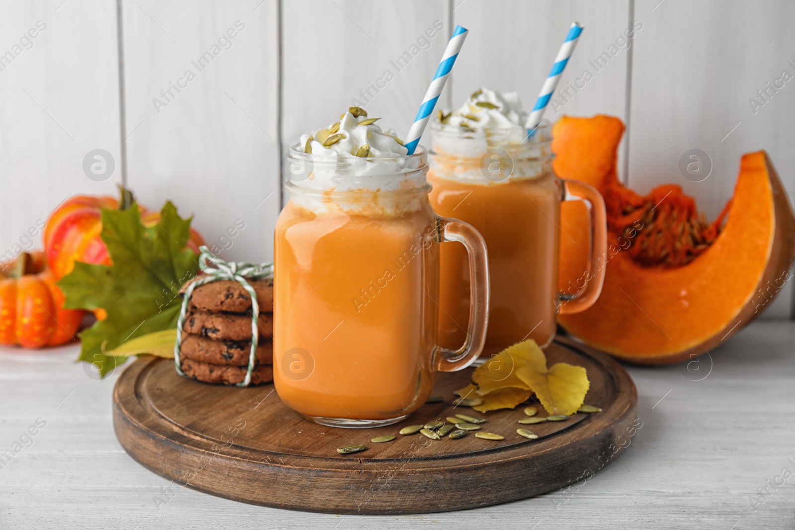 Photo of Composition with pumpkin spice latte in mason jars on table