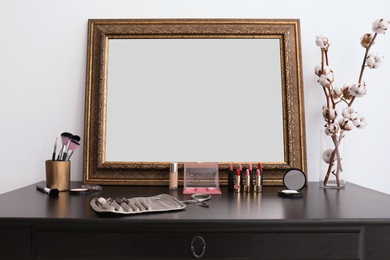 Photo of Decorative cosmetics and tools on dressing table near mirror in makeup room