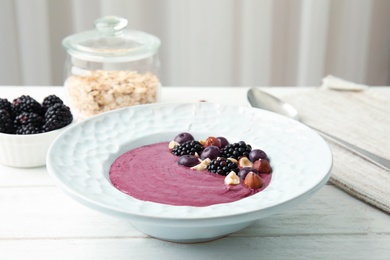 Photo of Plate of tasty acai smoothie on wooden table