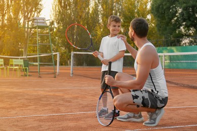 Photo of Father with his son on tennis court