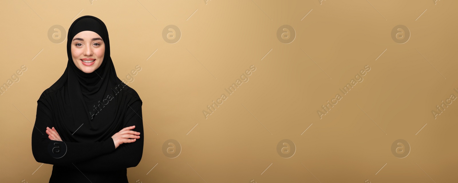 Image of Portrait of Muslim woman in hijab on beige background, space for text. Banner design