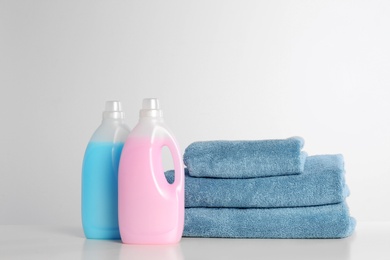 Photo of Detergents and clean towels on white background. Laundry day