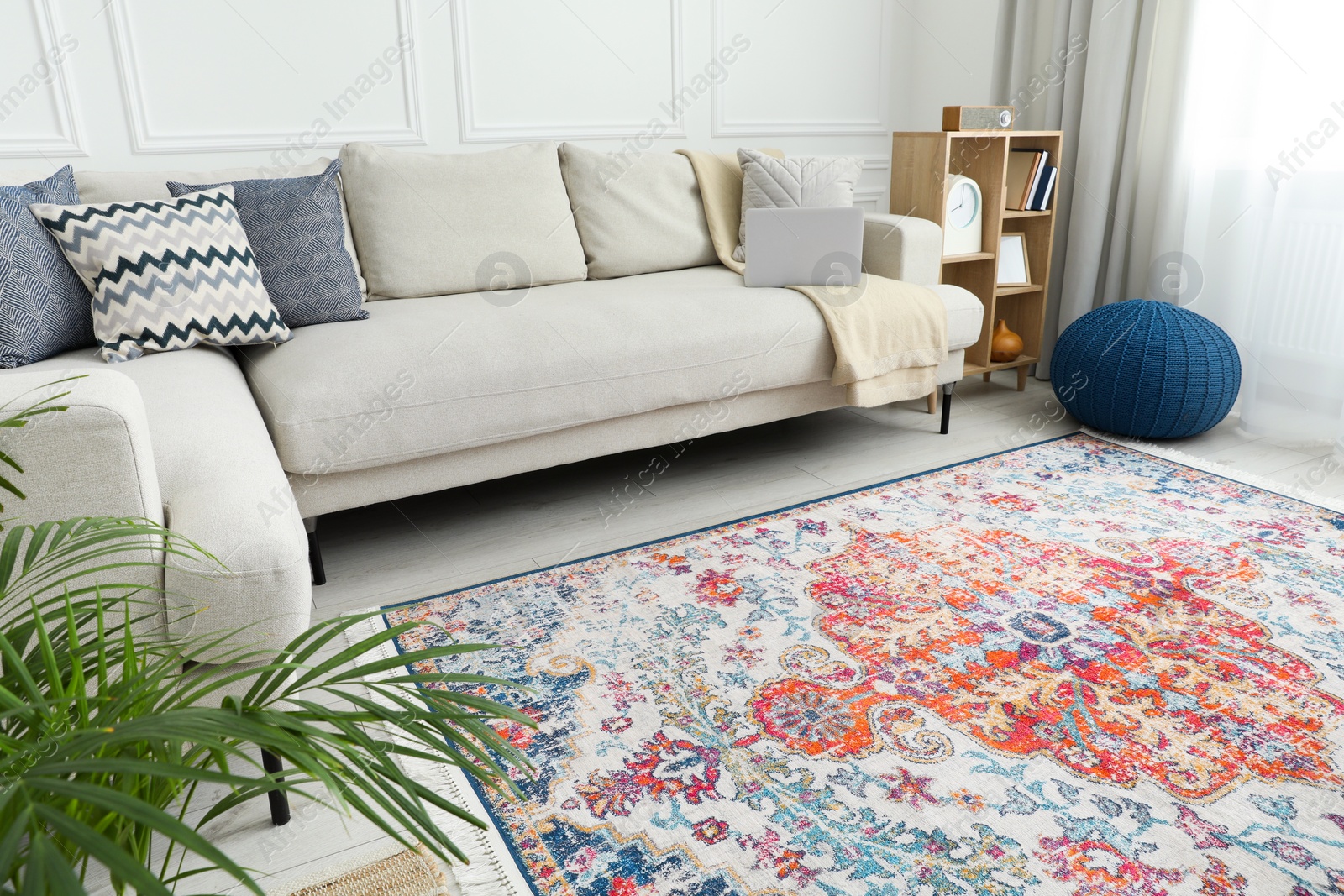 Photo of Stylish living room with beautiful carpet, comfortable sofa and laptop. Interior design