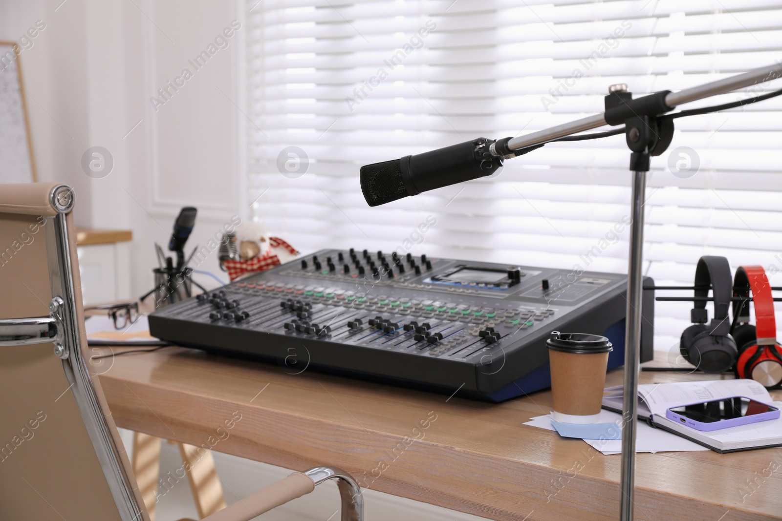 Photo of Microphone near professional mixing console in radio studio